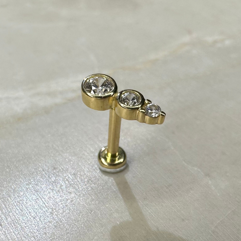 Yellow gold barrette helix piercing with three zircons