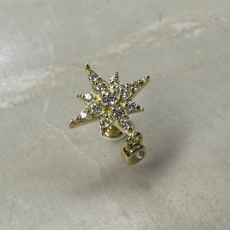 Star piercing with shiny pendant in yellow gold