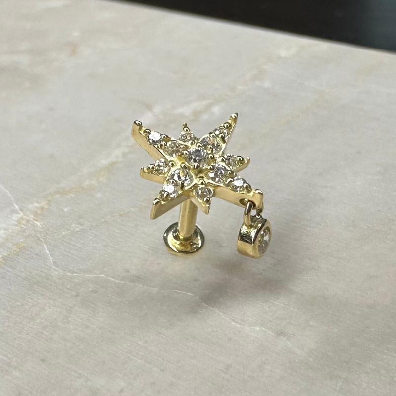 Star piercing with shiny pendant in yellow gold