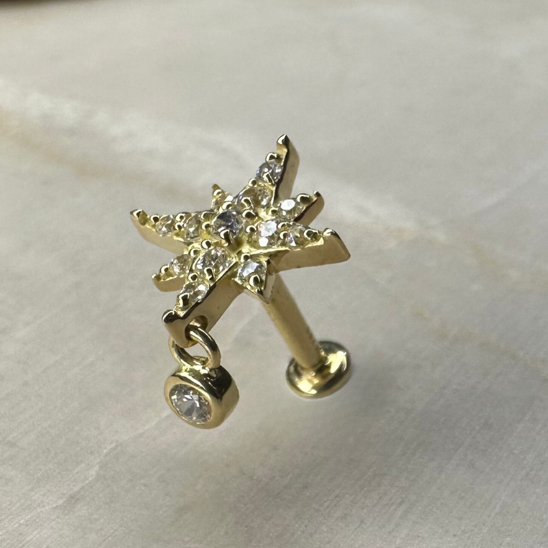 Star piercing with shiny pendant in yellow gold