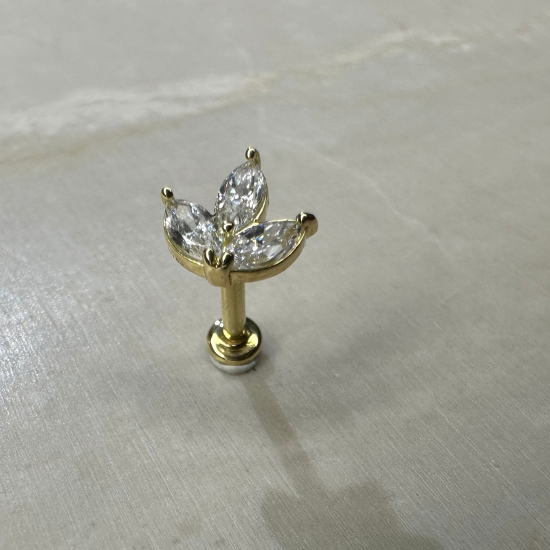 18-carat yellow gold ear piercing with flower and zircons