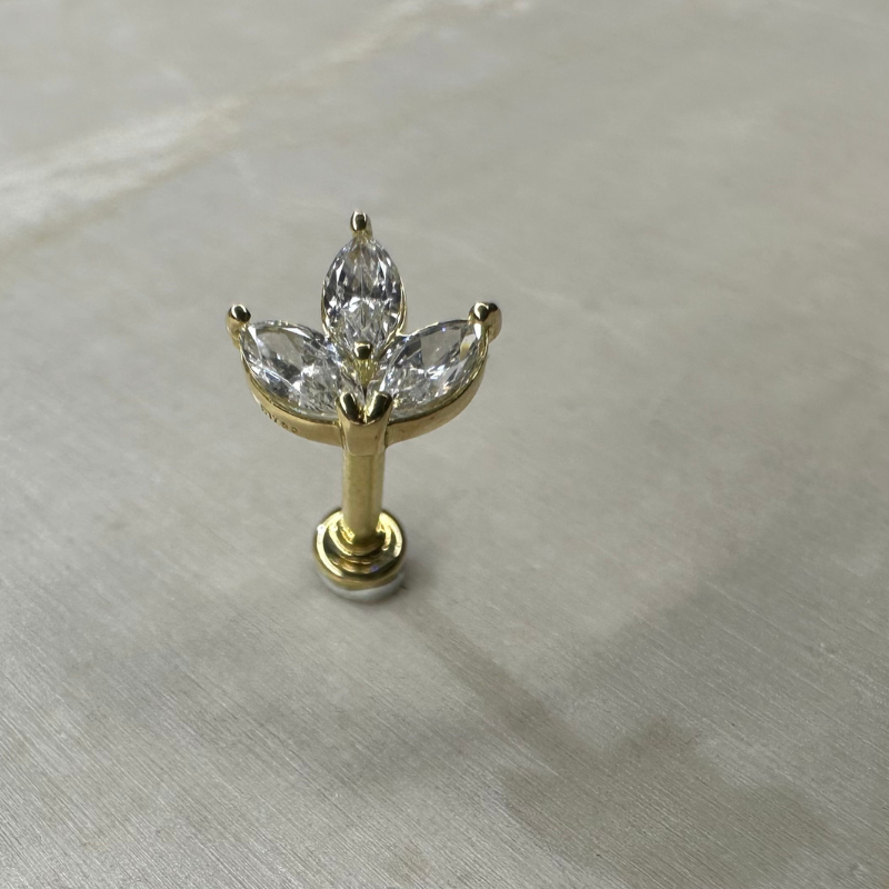 18-carat yellow gold ear piercing with flower and zircons