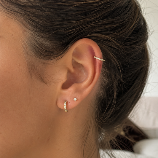 Anneau clicker en or jaune 18 carats serti de diamants porté à l'hélix sur une oreille femme – piercing luxe EZOR