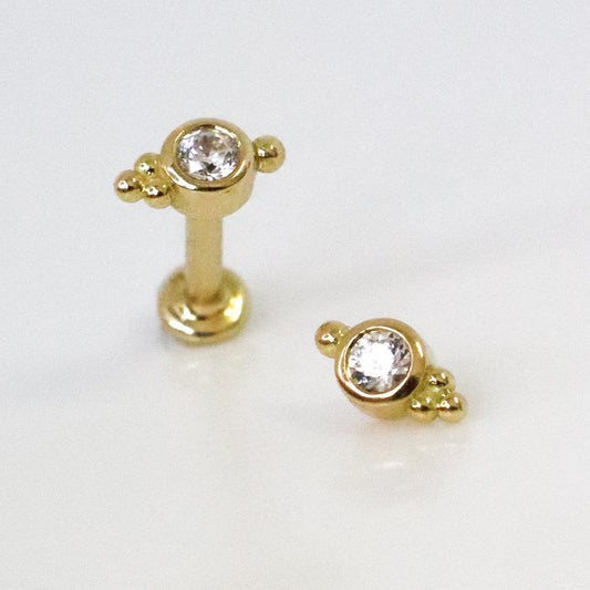 Piercing d'oreille avec zircon serti et trois petites boules en or jaune