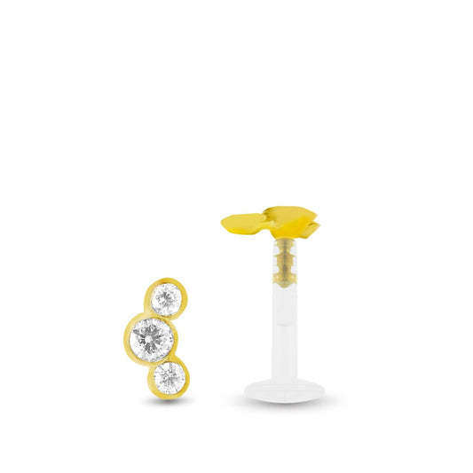 Piercing conch avec trois zircons blancs sertis sur une base en or jaune, à clipper dans le labret Bioplast.
