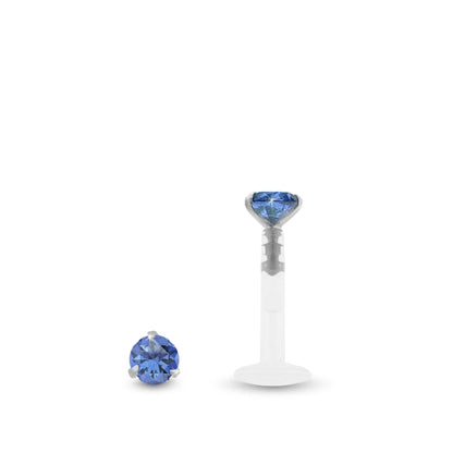 Piercing labret en or blanc avec zircon bleu foncé griffé sur une base en or blanc et barre en Bioplast.