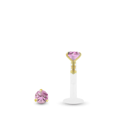 Piercing labret en or jaune avec zircon rose griffé et barre clipsable en Bioplast pour une pose facile.
