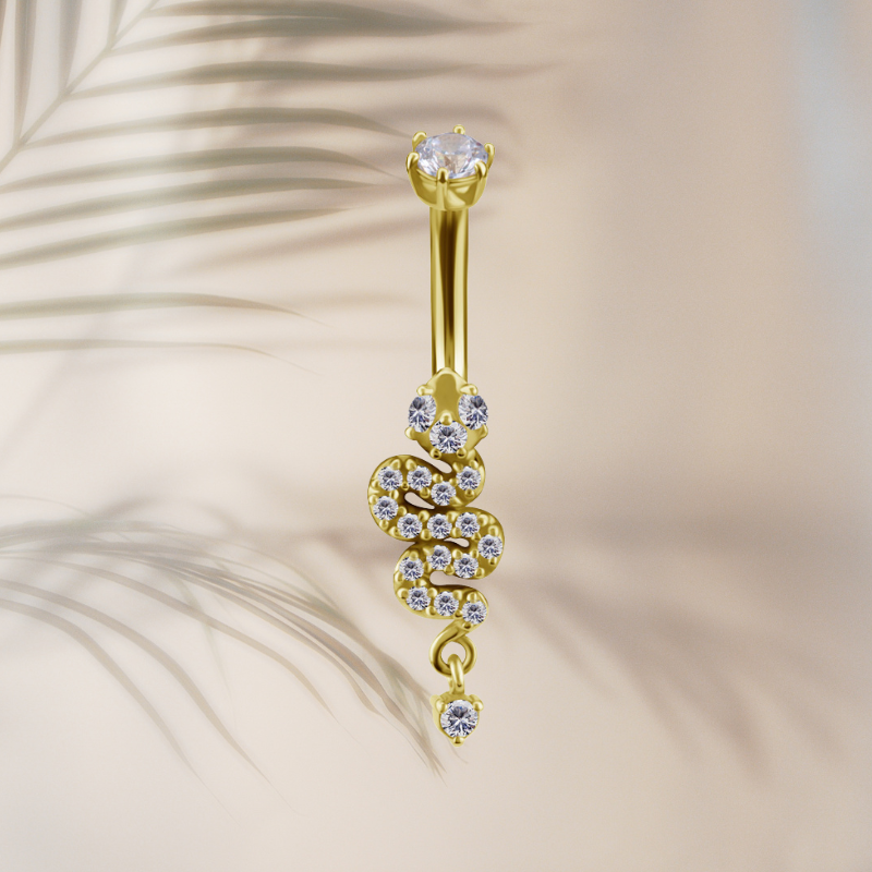 Piercing nombril serpent en or 18 carats sur fond ombre feuille