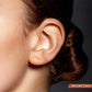 Yellow gold anti-helix piercing with light blue zirconium oxide